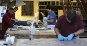 Simon is taking a rubbing of a stained glass window.